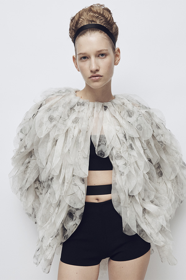 Max Mara Spring/Summer 2026 Fashion Show - Model with white Jacket Look with details, bandeau top and black Shorts.