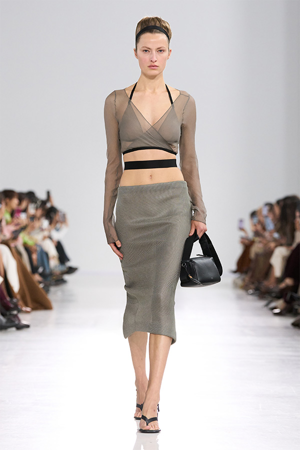 Max Mara Spring/Summer 2026 Fashion Show - Look with Crossover Top and Close-fitting Skirt with small black bag held in the hand.